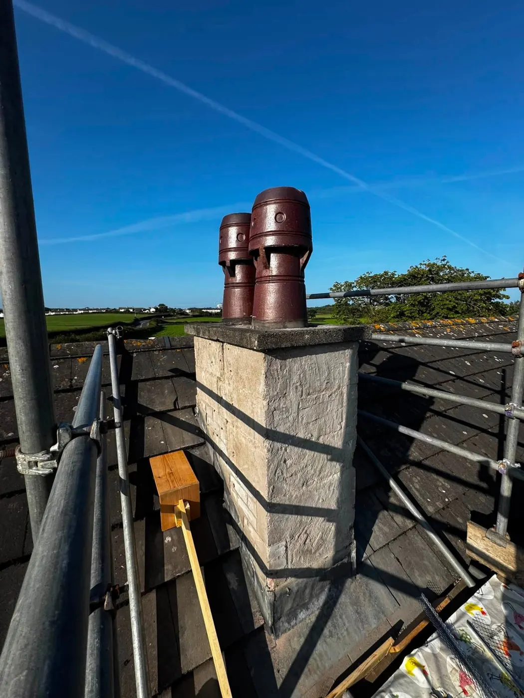 The same chimney stack before rendering, with scaffolding