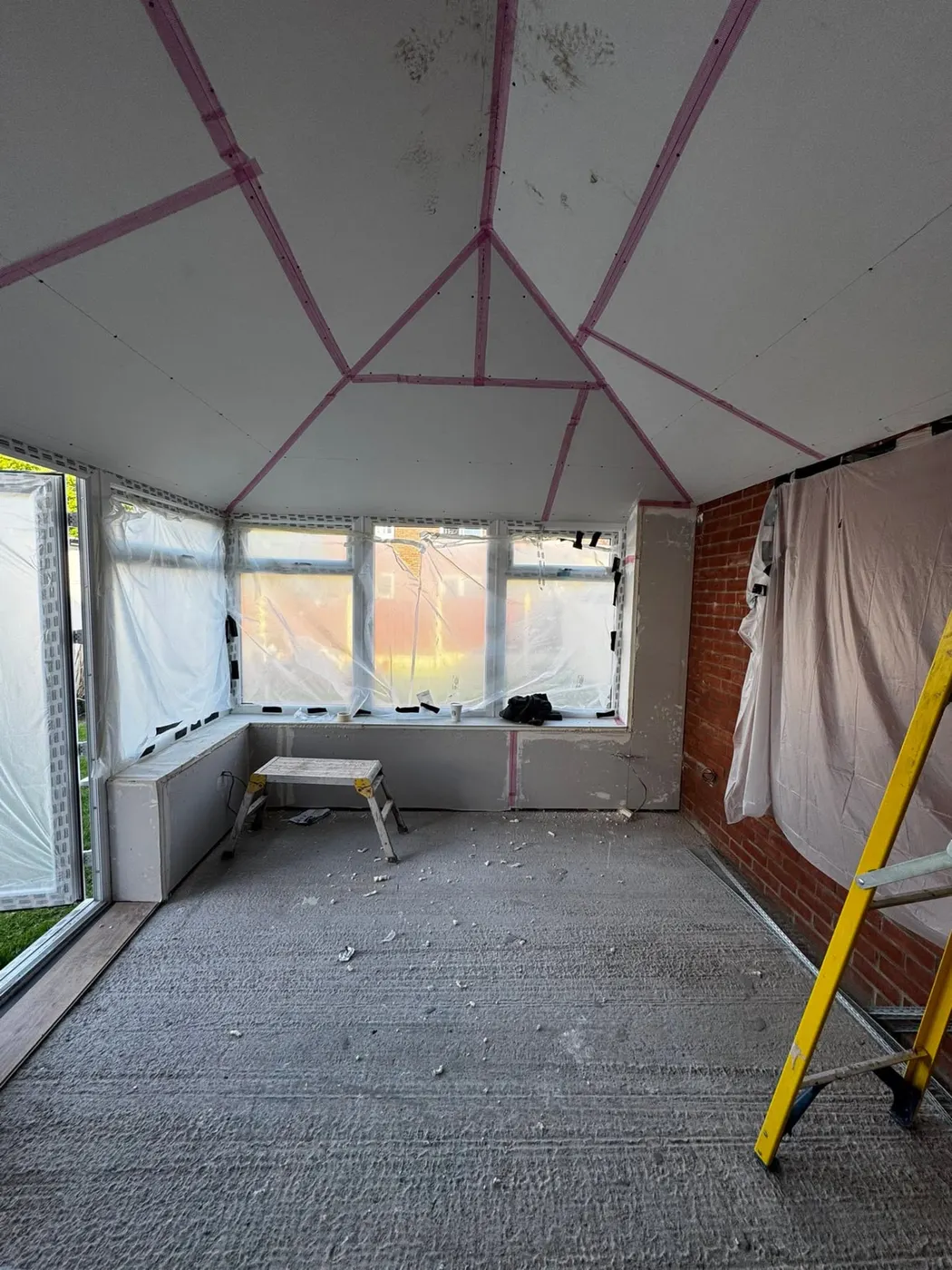 Room with taped plasterboard ceiling during work